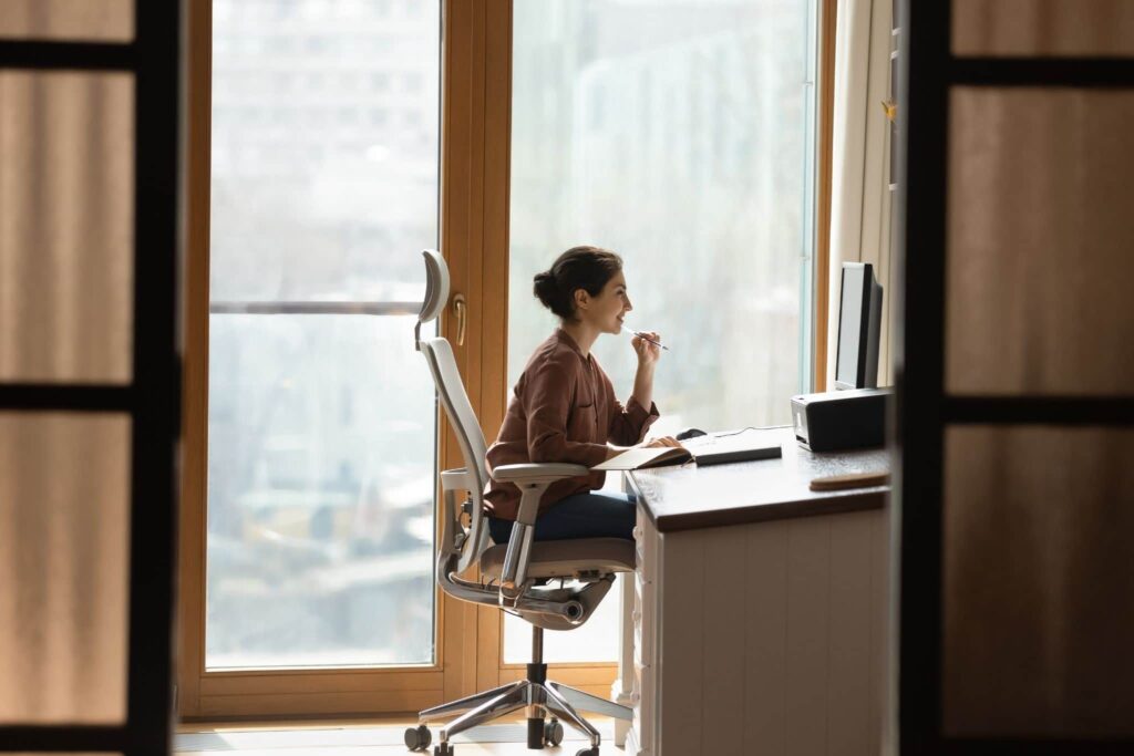 Women sitting in ergonomic chair while working in her home office