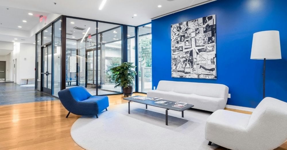 A brightly lit modern office lobby with a vibrant cobalt blue accent wall.