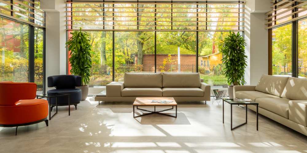 A bright lounge with sofas and chairs facing large windows.