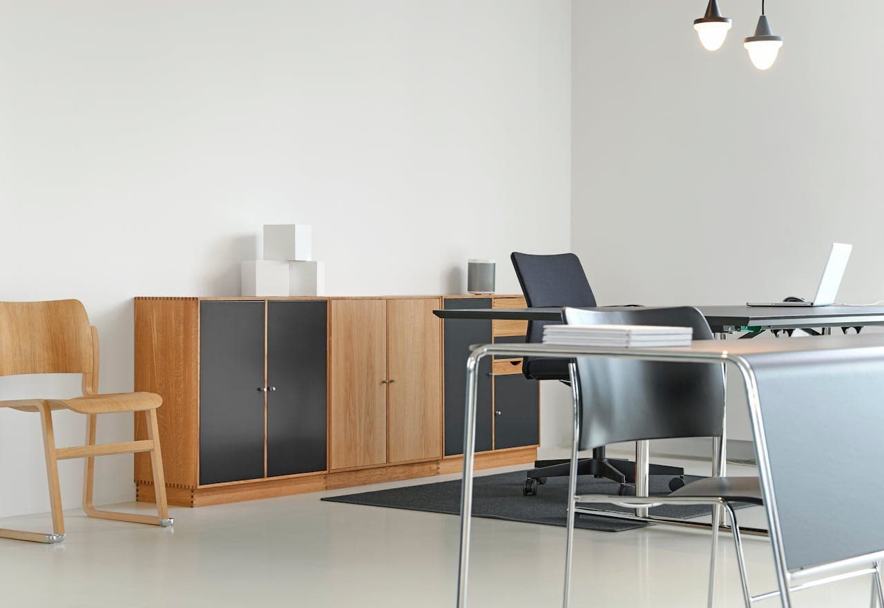 minimalist, modern office space featuring a light wood credenza