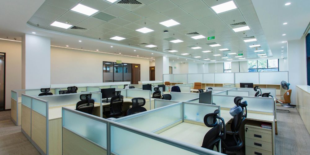 An open-plan office space featuring rows of modern cubicles