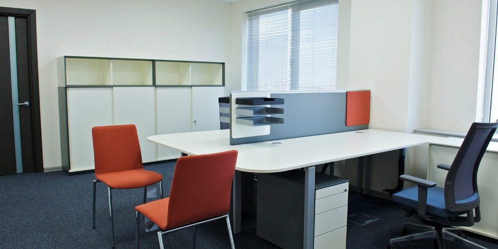 office cubicle setup featuring a large white double desk