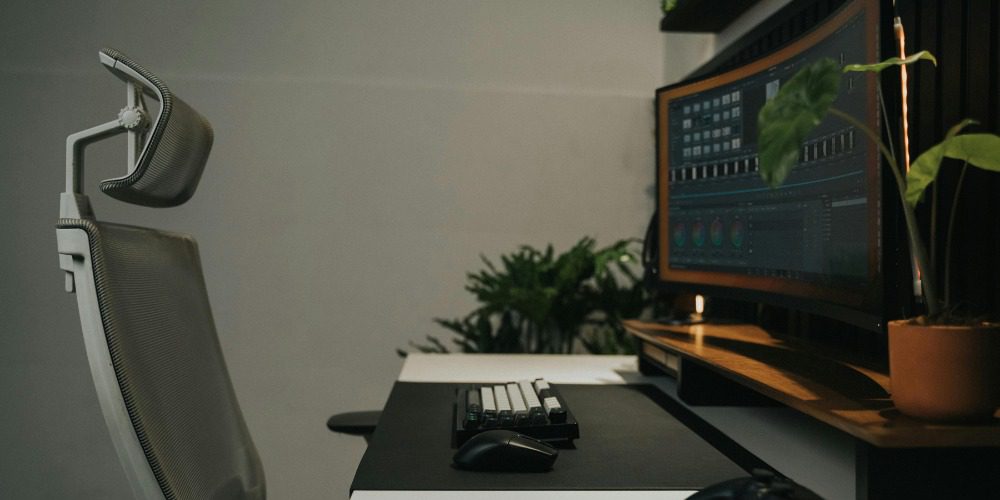An ergonomic office setup with a grey mesh chair