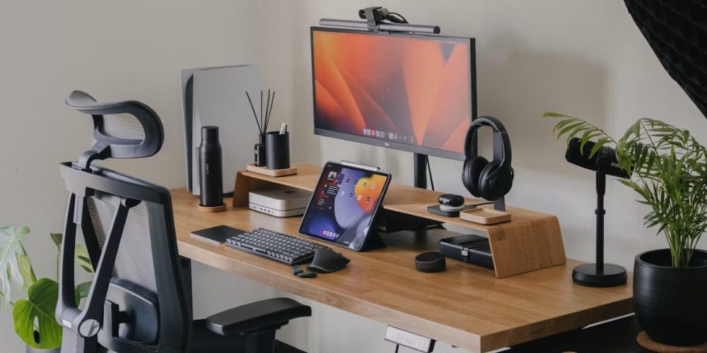 A modern wooden desk setup with an ergonomic mesh chair