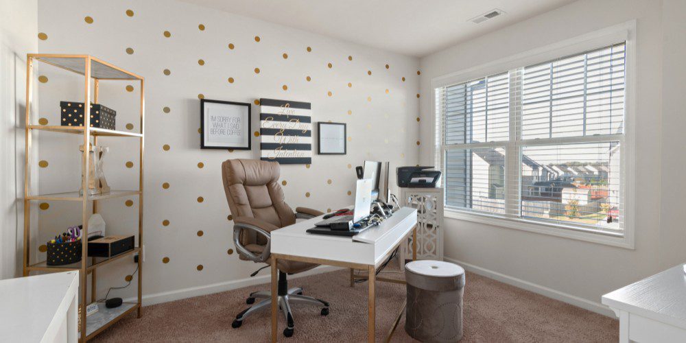 A chic home office featuring a white desk with gold legs