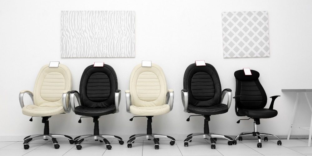 row of black and cream office chairs with price tags