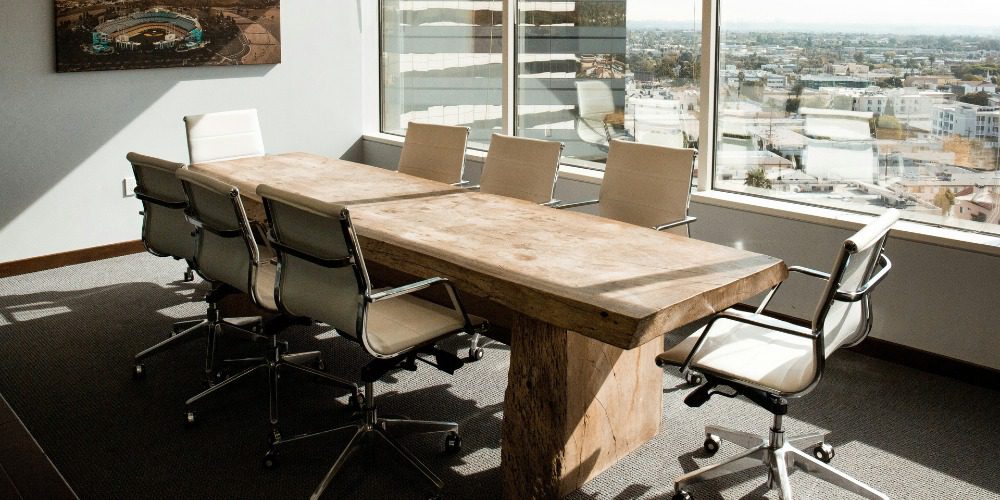 a conference room featuring a large, rustic live-edge wooden table